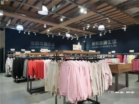 Simple clothing on racks beneath the LUDAO Ordinary Life sign